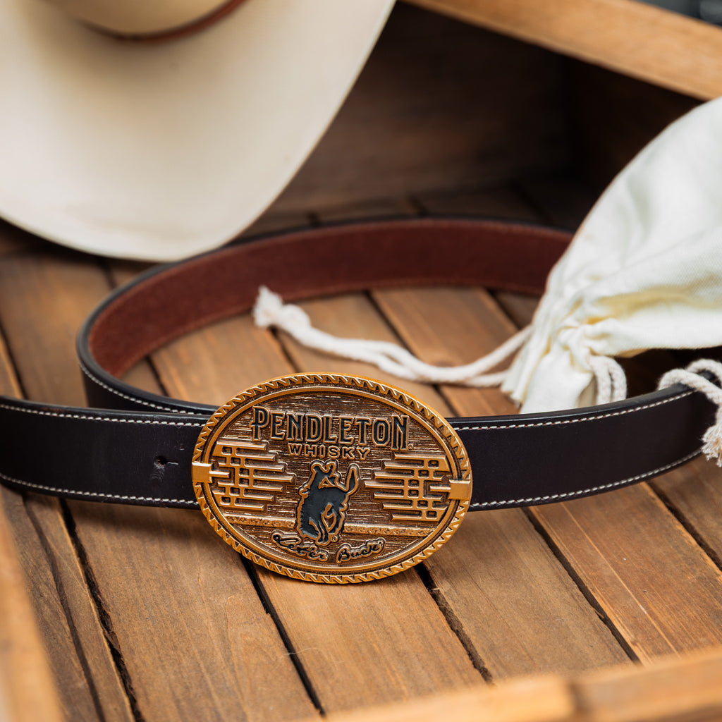 Image of the 2026 Pendleton Whisky Belt Buckle on a belt on top of a wooden box