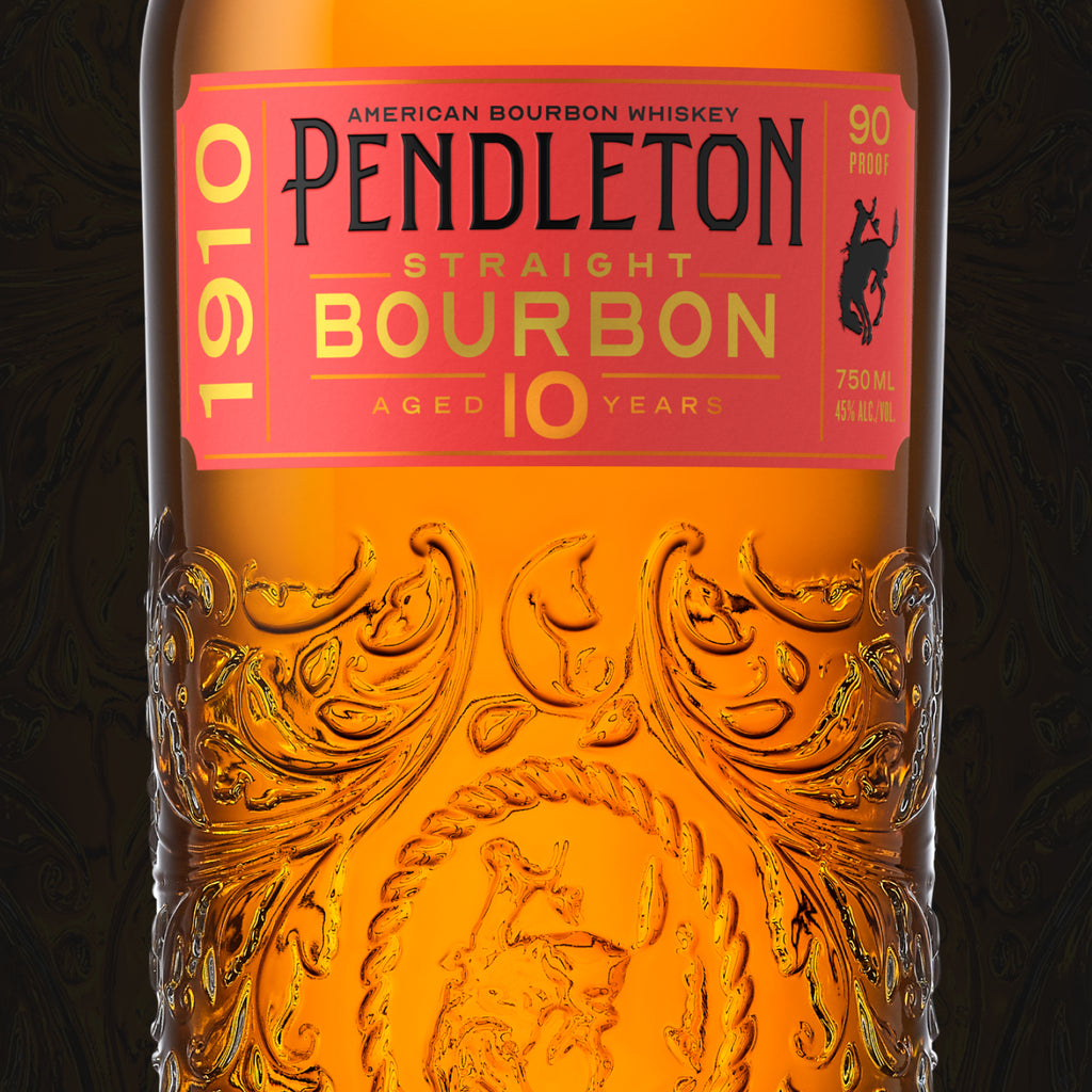 A close-up of a Pendleton 1910 Straight Bourbon Whiskey bottle. The label details the bourbon's age (10 years), proof (90), and volume (750 ml). The bottle has intricate gold and red designs.