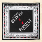 Flatlay of black, red, and white patterned Pendleton® Whisky Bandana on cream surface