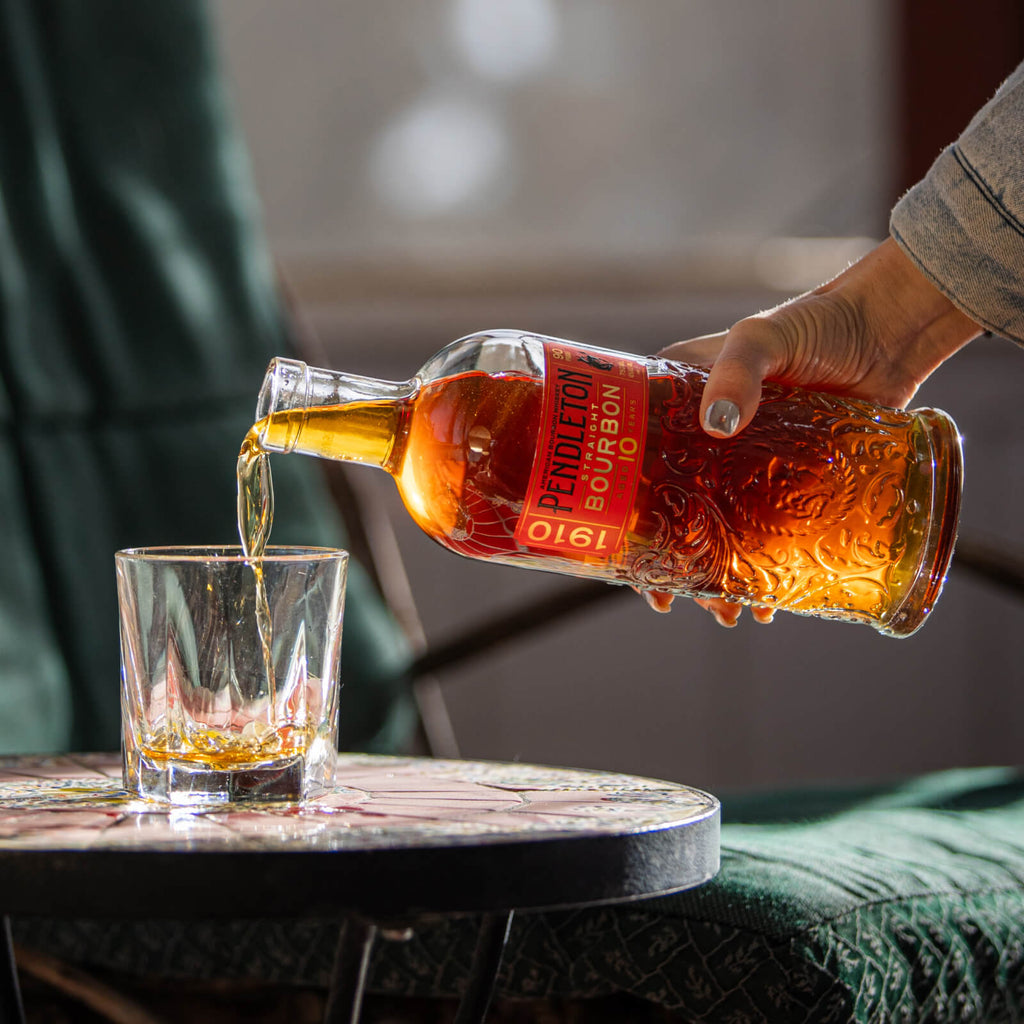 A bottle of Pendleton 1910 Straight Bourbon Whiskey. It's a 10-year-old bourbon with a gold and red label featuring intricate designs.