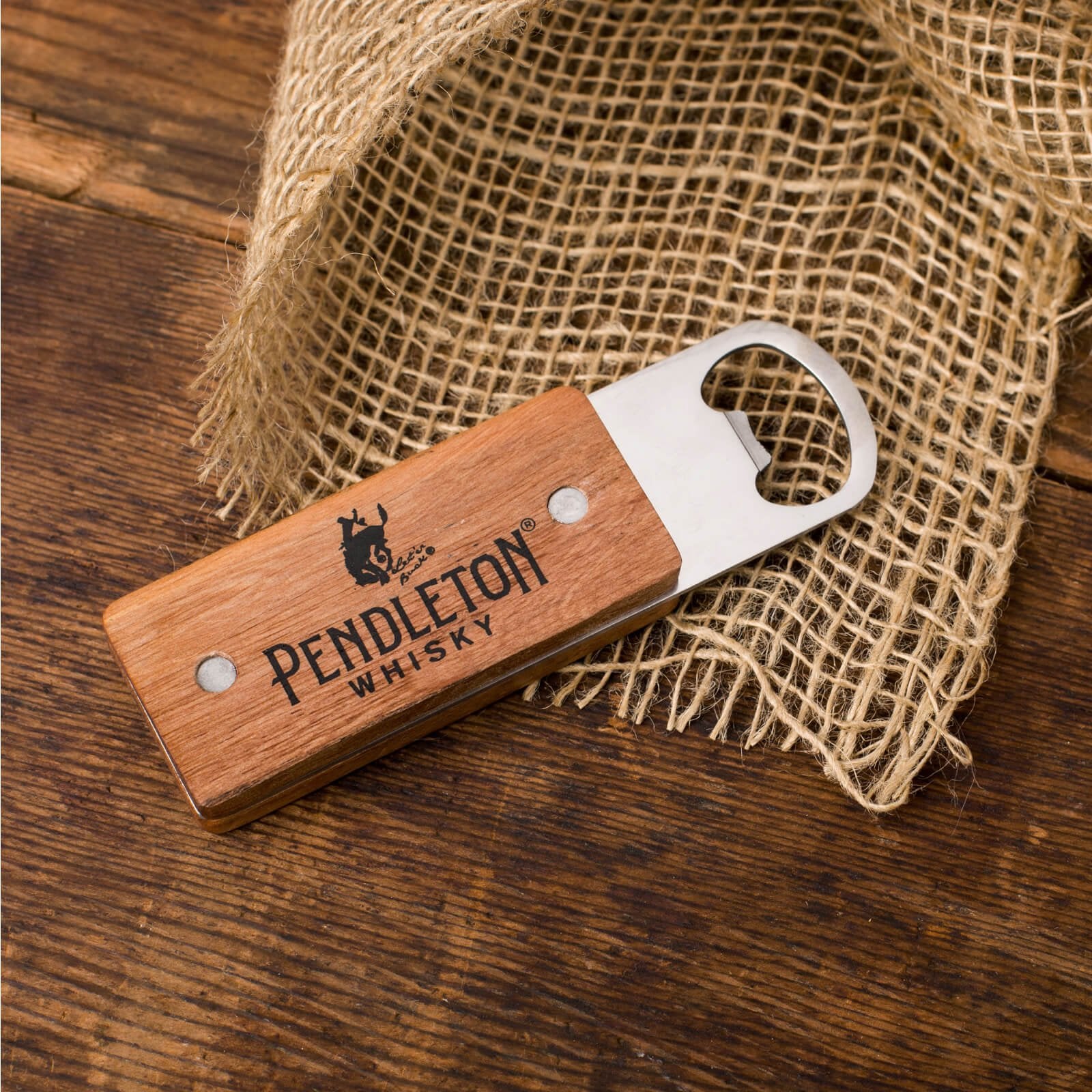 Pendleton® Whisky Wooden Paddle Bottle Opener on wood and burlap surface